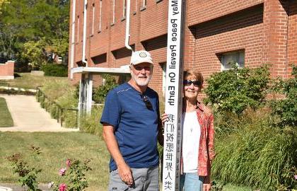 John Lersch ’79 (right) poses with the Peace Pole